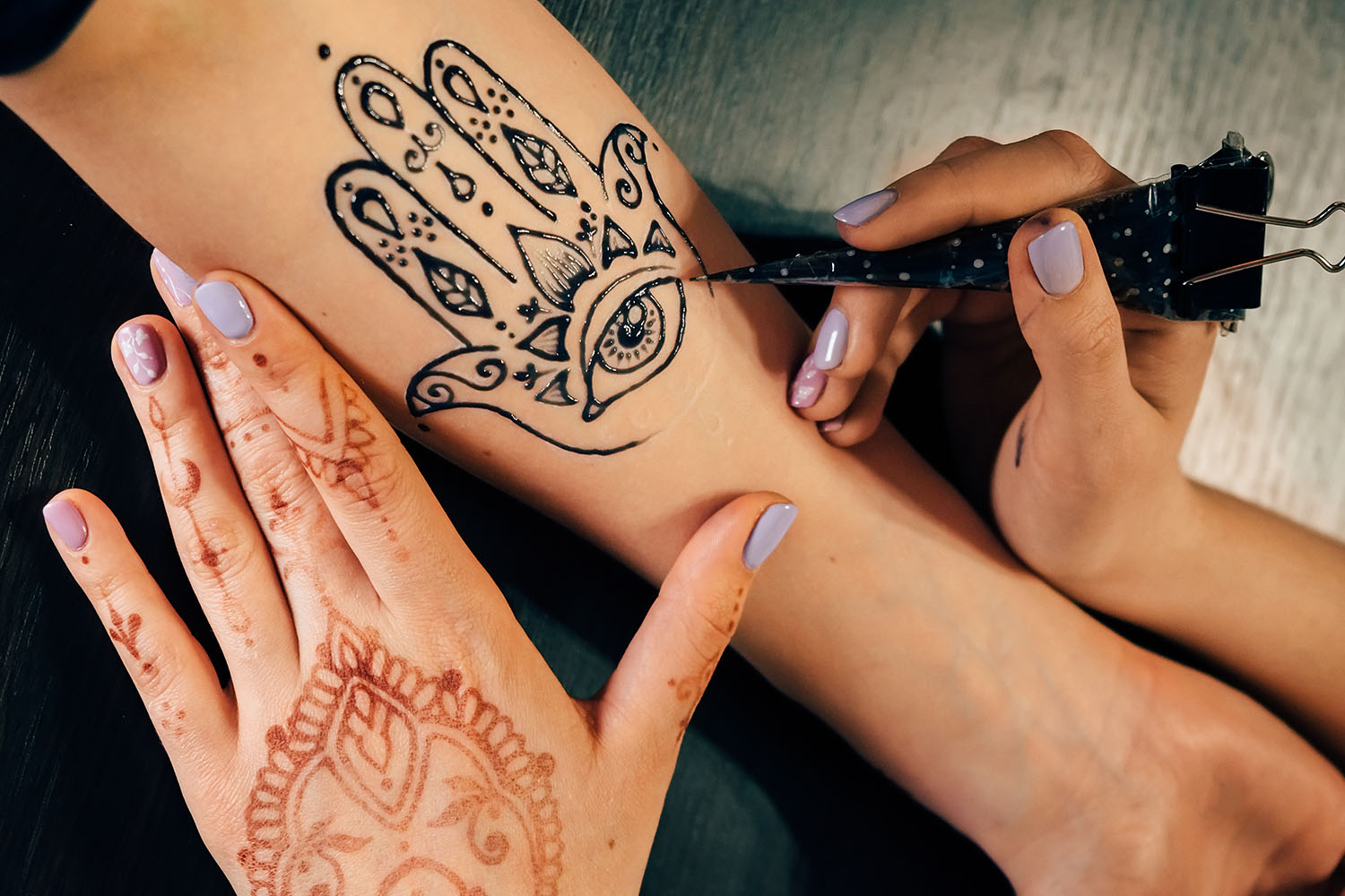 artist-applying-henna-mehndi-tattoo-female-hand