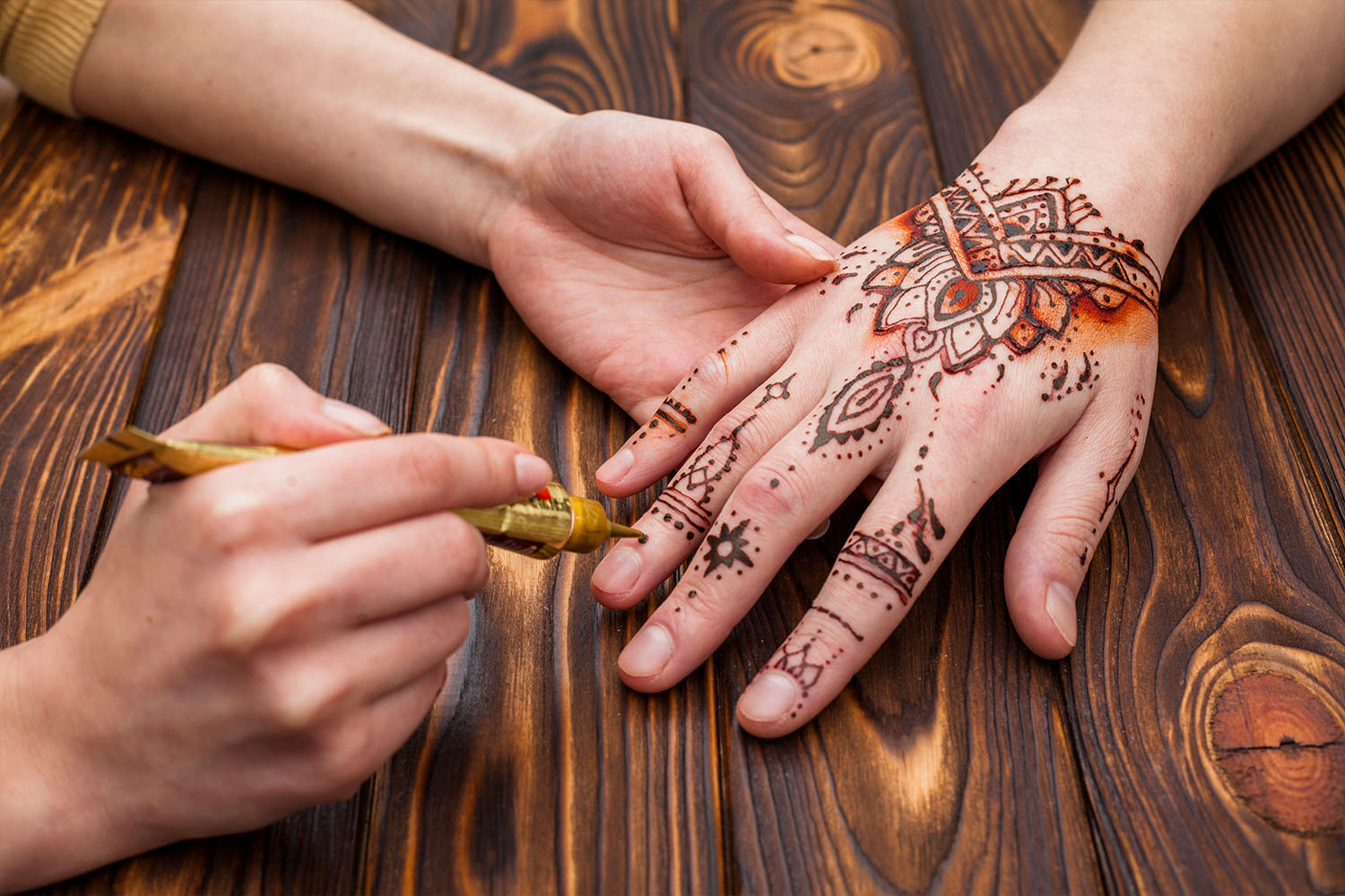 artist-making-mehndi-womans-hand