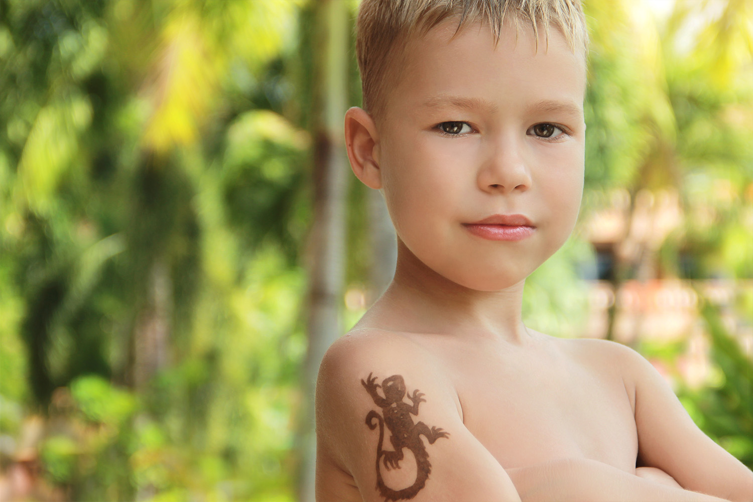 boy-with-temporary-tattoo-henna-his-shoulder-against-backdrop-palm-trees